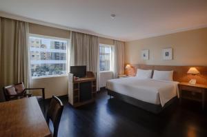 a hotel room with a bed and a desk and a tv at Park Inn by Radisson Berrini in Sao Paulo +69 photos