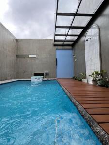 a large swimming pool in a building with a wooden deck at Alena Villa Private Pool in Blimbing +4 photos