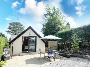 a patio with a table and chairs and an umbrella at The Coach House in Carnforth