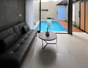 a living room with a couch and a table and a pool at Alena Villa Private Pool in Blimbing