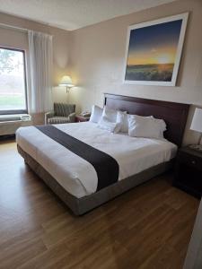 a hotel room with a large bed and a window at McPherson Inn in McPherson +13 photos