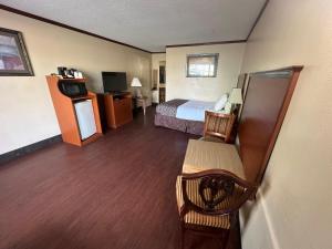 Una televisión o centro de entretenimiento en Hotel Red Rose by Townhouse Covington I-64