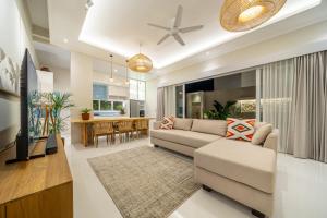 ein Wohnzimmer mit Sofa und Tisch in der Unterkunft 4Br Brand New Canggu Modern Villa in Tumbak Bayuh