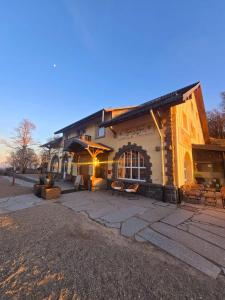 a large building with a patio in front of it at LA MAISON Crêperie-Bar-Hôtel in Le Valtin