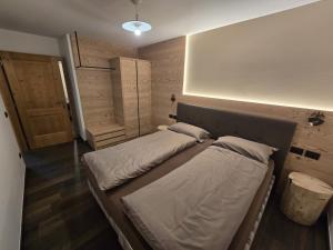 a bedroom with two beds and a door in it at Appartamento Rita in Pozza di Fassa