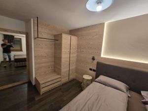 a bedroom with a bed and a wooden wall at Appartamento Rita in Pozza di Fassa +13 photos