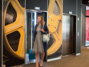 a woman is standing in front of a large wheel at Ibis Gdansk Stare Miasto in Gdańsk