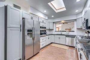 a kitchen with white cabinets and stainless steel appliances at Parkway Terrace in Tucson