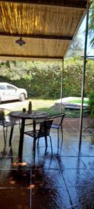 a patio with a table and chairs under a roof at El ceibo in Agua de Oro +2 photos