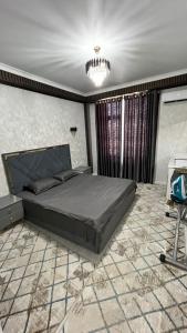 une chambre avec un grand lit et un lustre dans l'établissement КАРАВАН САРАЙ 15 Венеция, à Türkistan