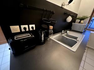 a kitchen counter with a sink and a microwave at Nid douillet proche orly aéroport in Athis-Mons +1 photo