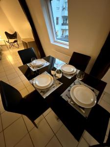 a dining room table with plates and chairs and a window at Nid douillet proche orly aéroport in Athis-Mons