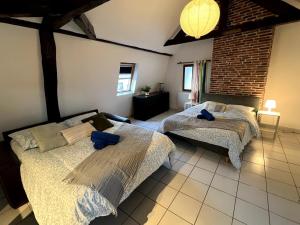 a bedroom with two beds and a brick wall at Nid douillet proche orly aéroport in Athis-Mons