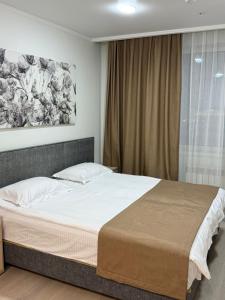 a bedroom with a bed and a painting on the wall at Yes apart hotel in Astana