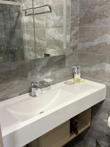 a bathroom with a white sink and a mirror at Yes apart hotel in Astana