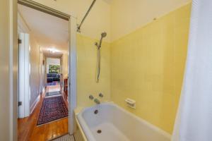 a bath tub in a bathroom with a yellow wall at Casita #7 in Tucson +13 photos
