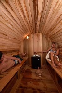 two people laying on beds in a wooden igloo at Hotel Les Mélèzes in Haudères