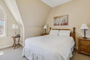 a bedroom with a large white bed and two lamps at 225 Snowbridge with Village Shuttle in Collingwood +35 photos