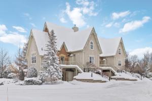 a large house with a snow covered roof at 225 Snowbridge with Village Shuttle in Collingwood