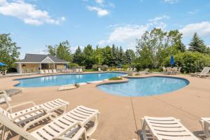 a swimming pool with lounge chairs in a resort at 225 Snowbridge with Village Shuttle in Collingwood