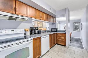 a kitchen with white appliances and wooden cabinets at 2BDR Condo Steps to Blue Mountain Village - 101 Cachet Crossing in Blue Mountains