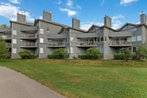 an apartment building with a lawn in front of it at 2BDR Condo Steps to Blue Mountain Village - 101 Cachet Crossing in Blue Mountains
