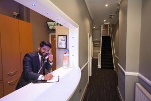 a man talking on a phone at a counter at St George's Inn Victoria in London