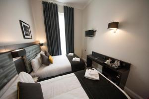 a hotel room with a bed and a desk at St George's Inn Victoria in London