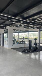 ein Fitnessstudio mit einem Haufen Trainingsgeräte in einem Raum in der Unterkunft Studios super modernos, completos e equipados no centro de Pará de Minas in Pará de Minas