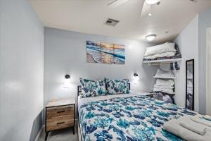 a bedroom with a bed with a blue bedspread at Seashell Retreat - Beachfront Condo with Pools and Cabanas in Galveston