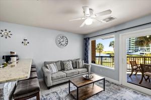 a living room with a couch and a table at Seashell Retreat - Beachfront Condo with Pools and Cabanas in Galveston +26 photos
