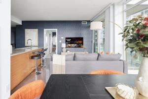 Stylish Downtown - Condo Sleeps 8 - YYZ Airport في ميسيساوغا: مطبخ وغرفة معيشة مع أريكة وطاولة