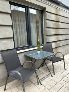una mesa de cristal y 2 sillas en el patio en Apartament Luxury, en Bucarest