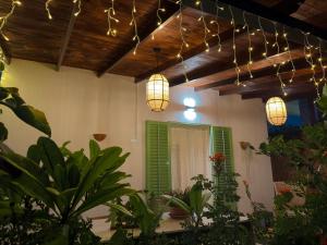 una stanza con luci appese a un soffitto con piante di Villa Clara - Comfort e natura nel cuore di Sambuca a Sambuca di Sicilia