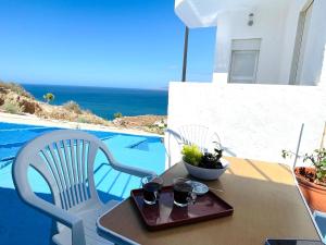 Una mesa con dos sillas y una bandeja con bebidas encima. en Luxurious condo with patio and terrace, en Alhucemas