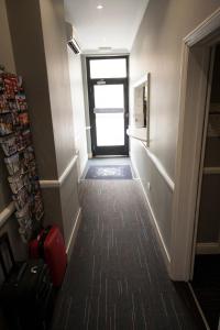 a hallway with a door leading to a room with a window at St George's Inn Victoria in London +32 photos
