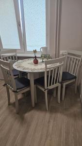 a white table and chairs with a table and a window at Kambarių nuoma Kaune Taikos pr in Kaunas +3 photos