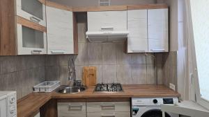 a small kitchen with a sink and a stove at Kambarių nuoma Kaune Taikos pr in Kaunas