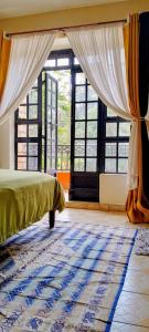 Turquoise Haven في نيروبي: غرفة نوم بسرير ونوافذ وسجادة