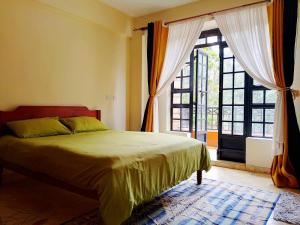 Turquoise Haven في نيروبي: غرفة نوم بها سرير ونافذة كبيرة