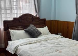 una cama con cabecero de madera y almohadas en MeroBasai - Budhanilkantha Residence, en Burhānilkantha 4 fotos más