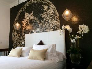 a bedroom with a white bed with a black wall at Hotel Villa Rose in Nice