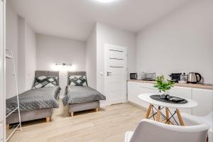 a bedroom with a bed and a table and a kitchen at Central Platinum Apartments 25 Studio z aneksem kuchennym i tarasem in Rybnik