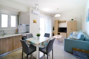 a kitchen and living room with a table and a couch at Breeze Apartment Nikiti in Nikiti