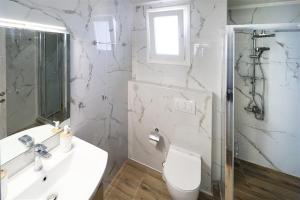 a bathroom with a toilet and a sink and a shower at Breeze Apartment Nikiti in Nikiti +11 photos