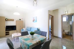 a living room with a blue couch and a table at Breeze Apartment Nikiti in Nikiti