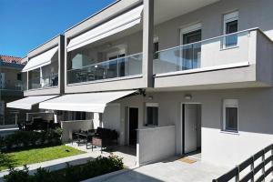 a building with a balcony with tables and chairs at Breeze Apartment Nikiti in Nikiti