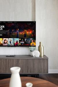 Sleek Sq 1 Downtown Condo - 4 beds - Parking في ميسيساوغا: غرفة معيشة مع تلفزيون بشاشة مسطحة على الحائط