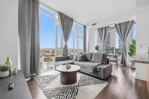 Sleek Sq 1 Downtown Condo - 4 beds - Parking في ميسيساوغا: غرفة معيشة مع أريكة ونوافذ كبيرة +33 صورة