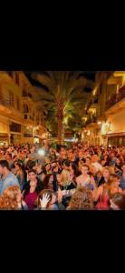 una gran multitud de personas de pie en una calle en Irooms770, en Haifa